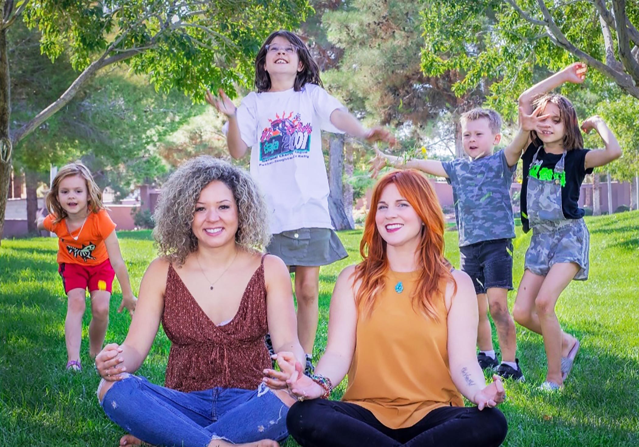 Brooke and Kristen meditating in a park.